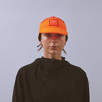 Transit Lite Cap - Neon Orange / Coral — VÅGA running cap — worn, front view